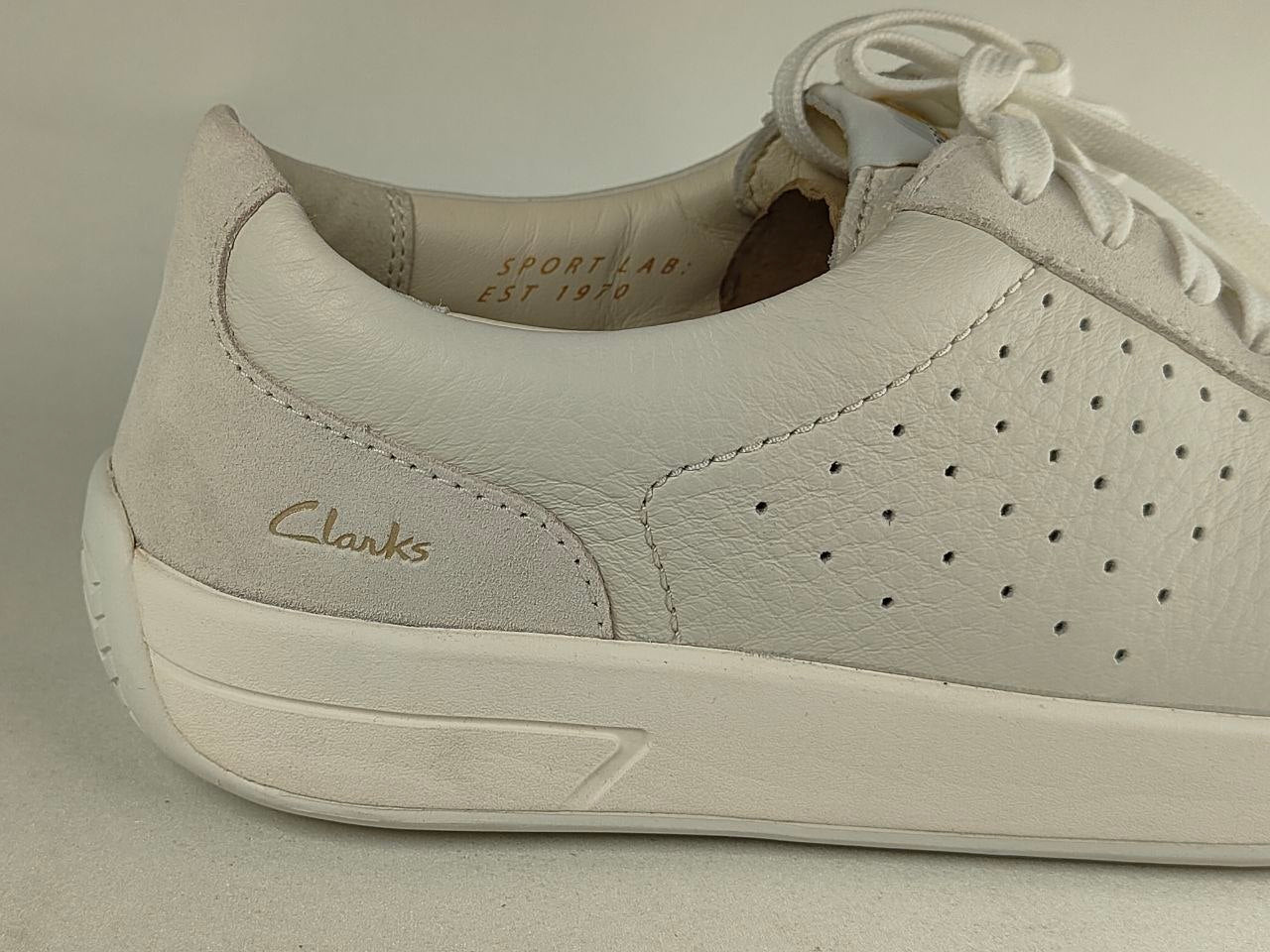 Beige sneaker with 'Clarks' branding on a neutral background