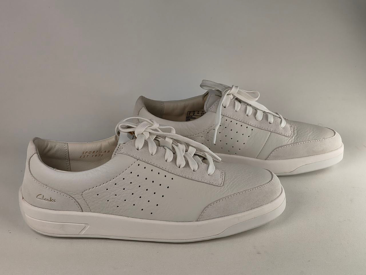 Pair of light gray sneakers on a gray background