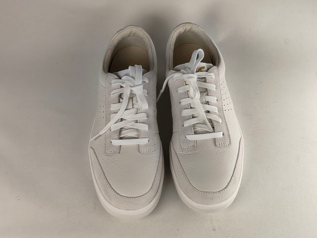 Pair of white sneakers on a light gray background