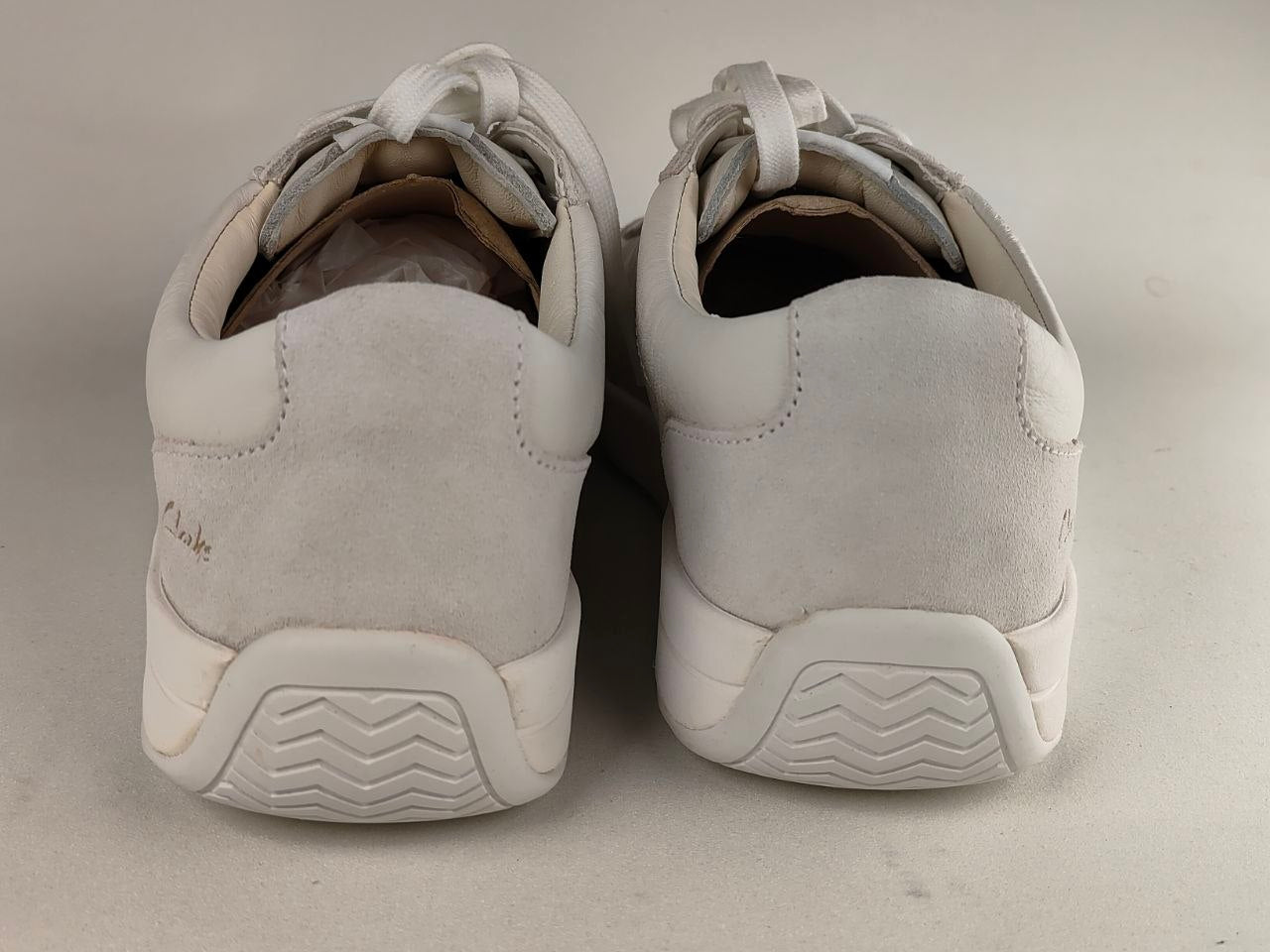 Pair of light gray sneakers on a neutral background