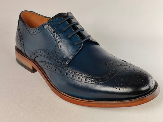 Navy blue leather wingtip shoe on a light gray background