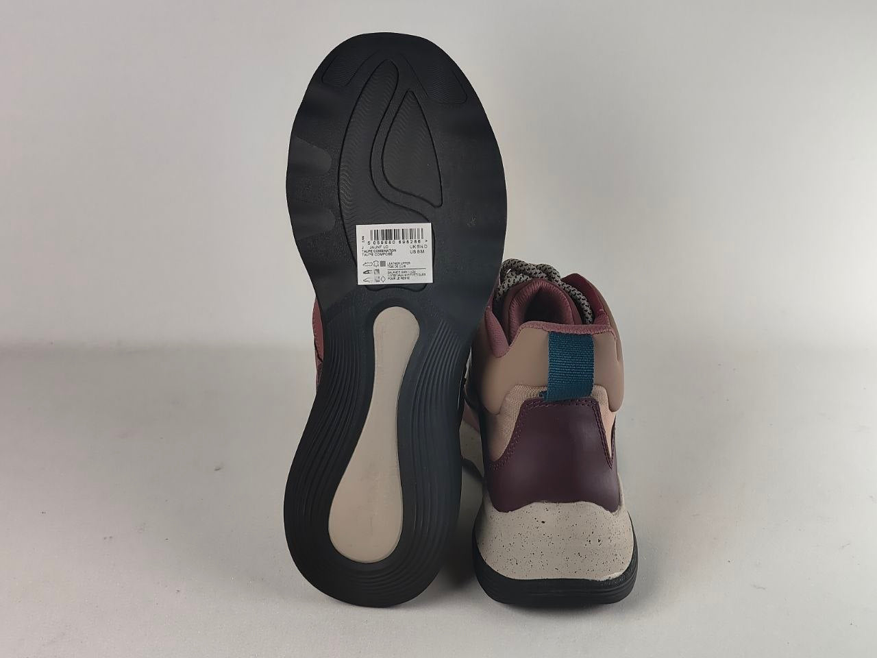 A pair of high-top sneakers shown from the back, displaying the black outsole and the side profile. The shoes feature color-blocked panels of burgundy, beige, and a teal blue accent.