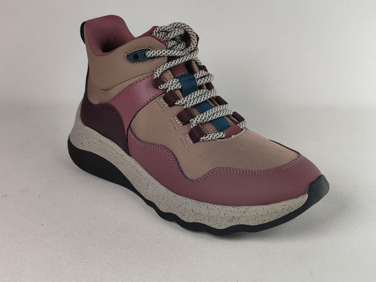 A mid-top athletic sneaker in dusty rose and beige, featuring chunky gray-and-white braided laces with blue accents, a speckled light gray midsole, and a black outsole.
