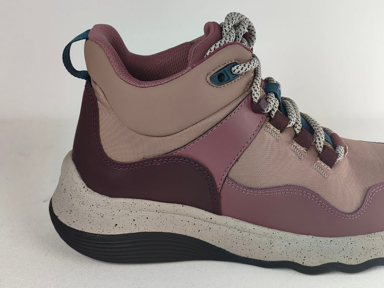 A mid-top hiking boot shown in a side profile view against a plain light background. The boot features a color-blocked design with dusty rose, mauve, and taupe panels, a chunky speckled off-white midsole, and gray-and-white braided laces.