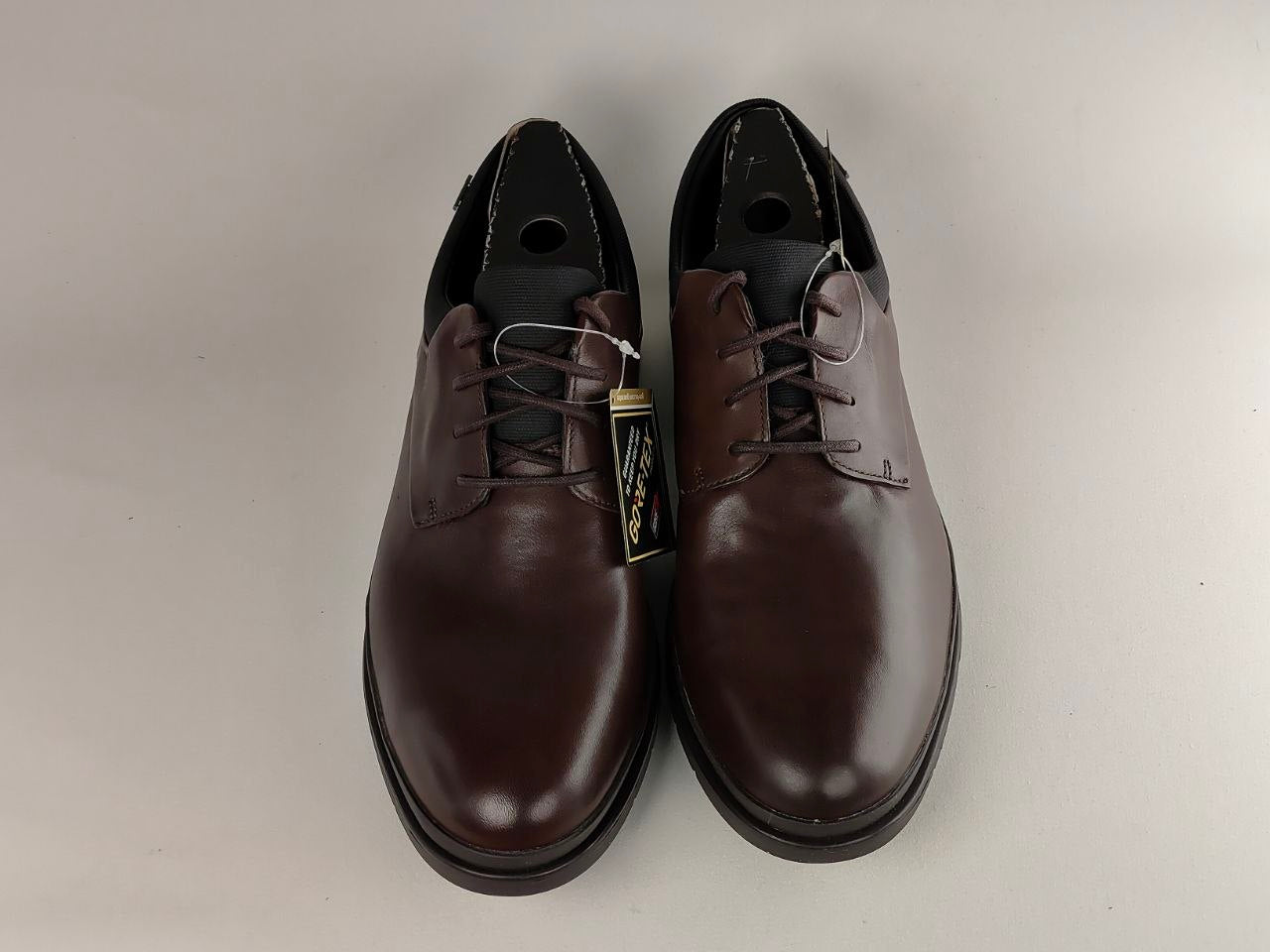 Pair of brown leather shoes on a light gray background
