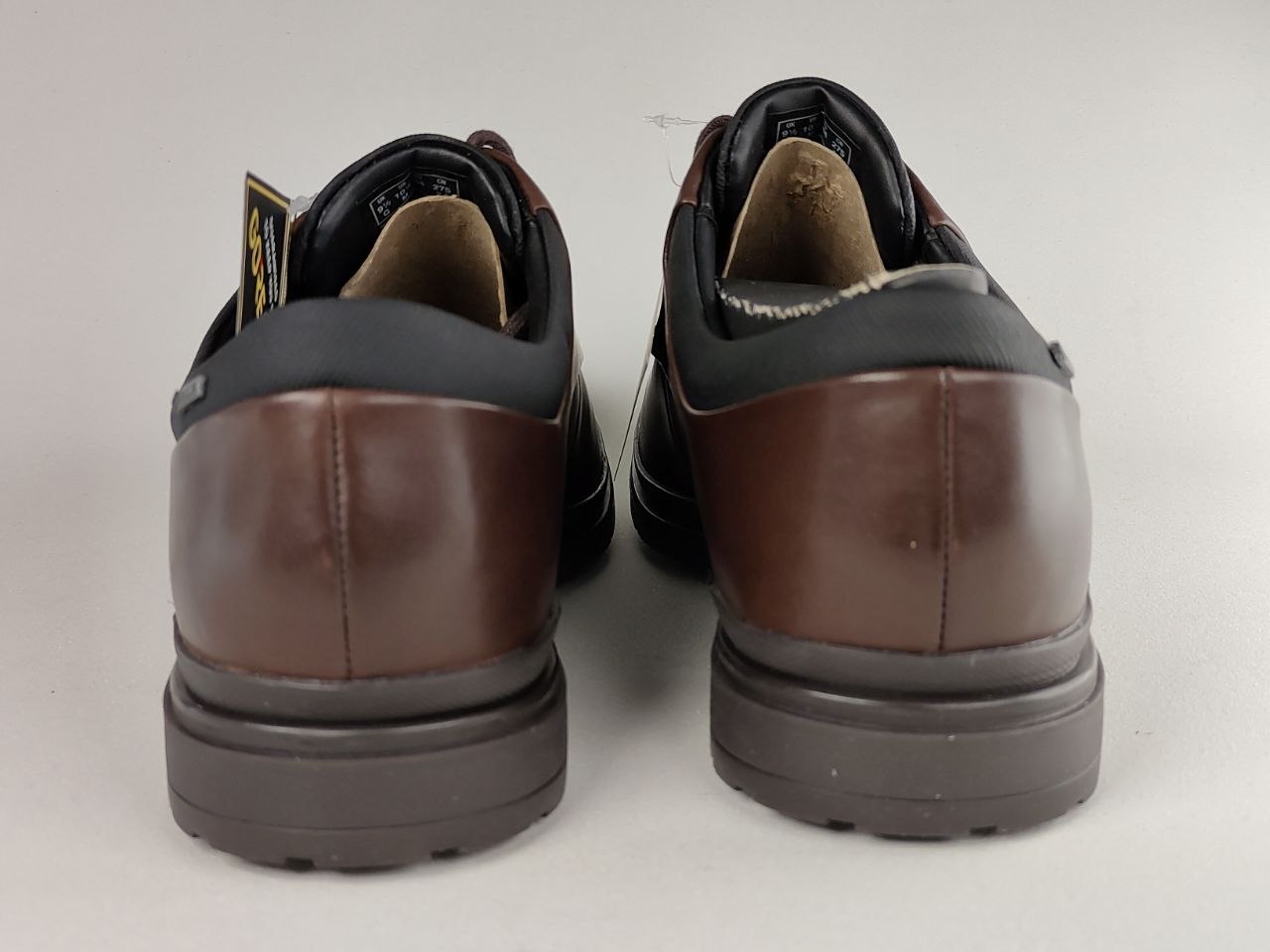 Pair of brown leather shoes with black soles on a white background