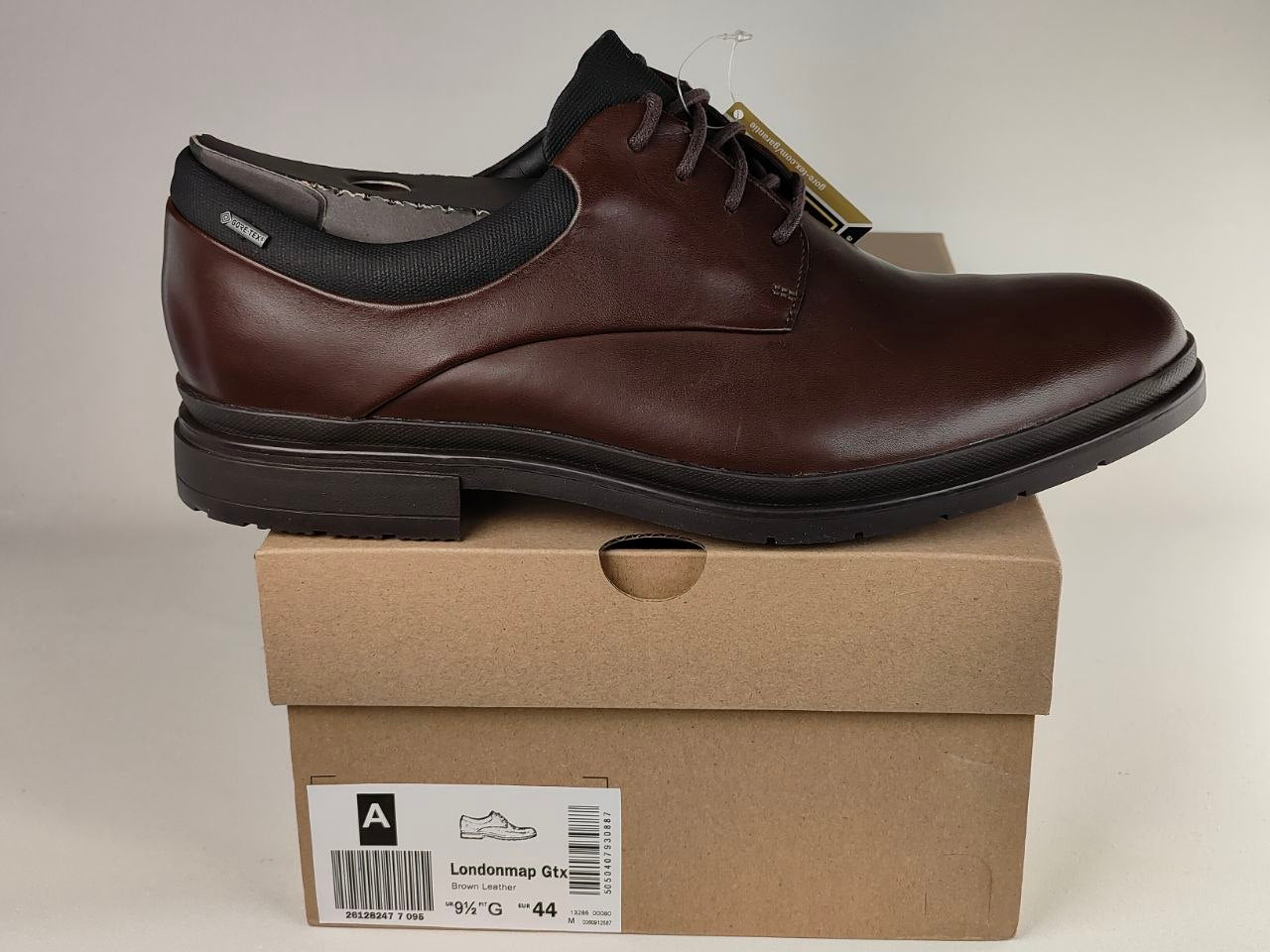 Brown leather shoe on a cardboard box with a visible brand label.