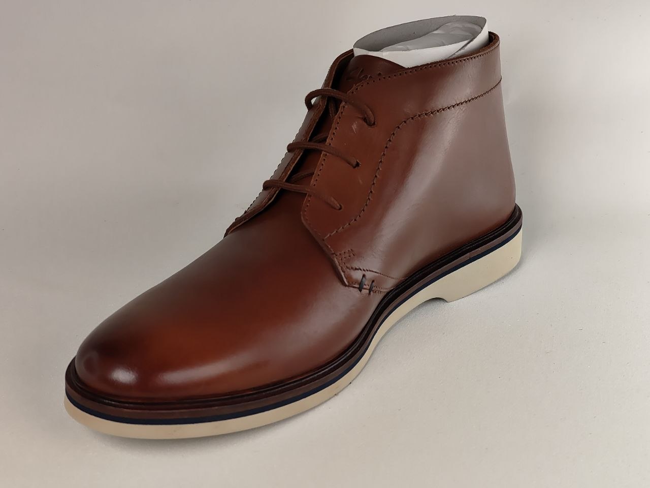 Brown leather shoe on a beige background