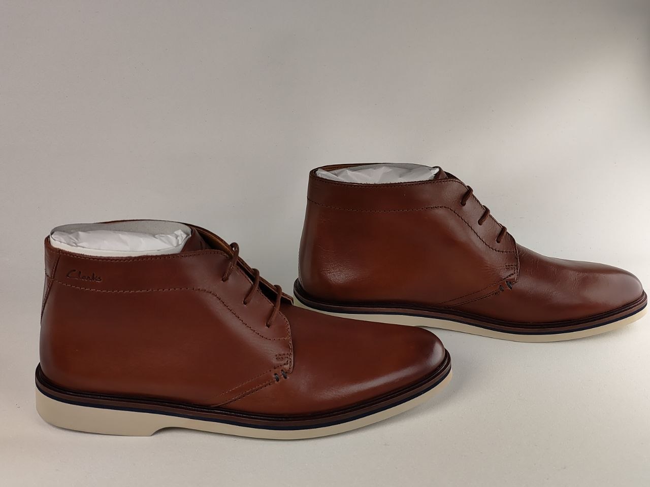 Pair of brown leather chukka boots on a light gray background