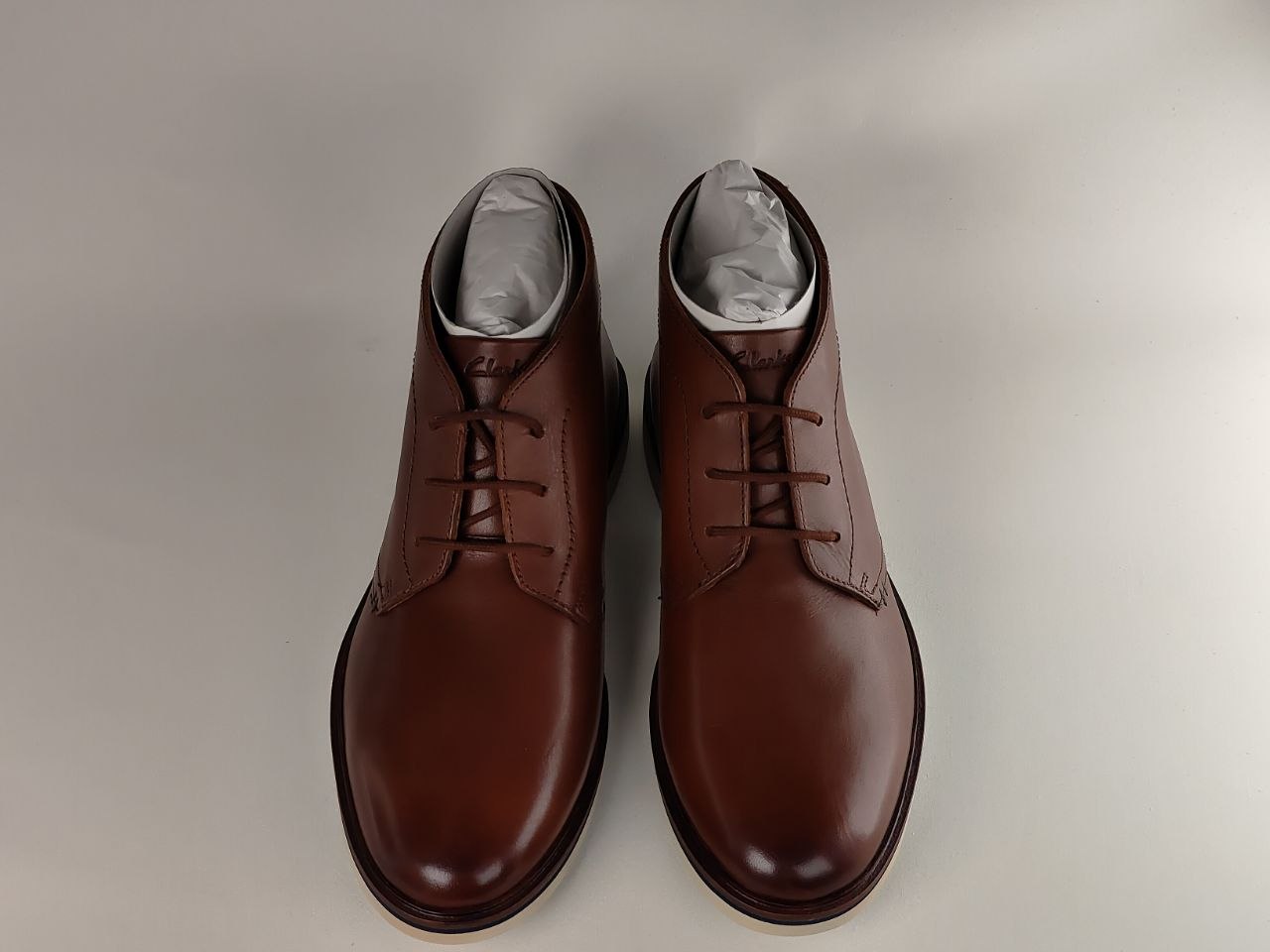 Pair of brown leather boots on a light gray background