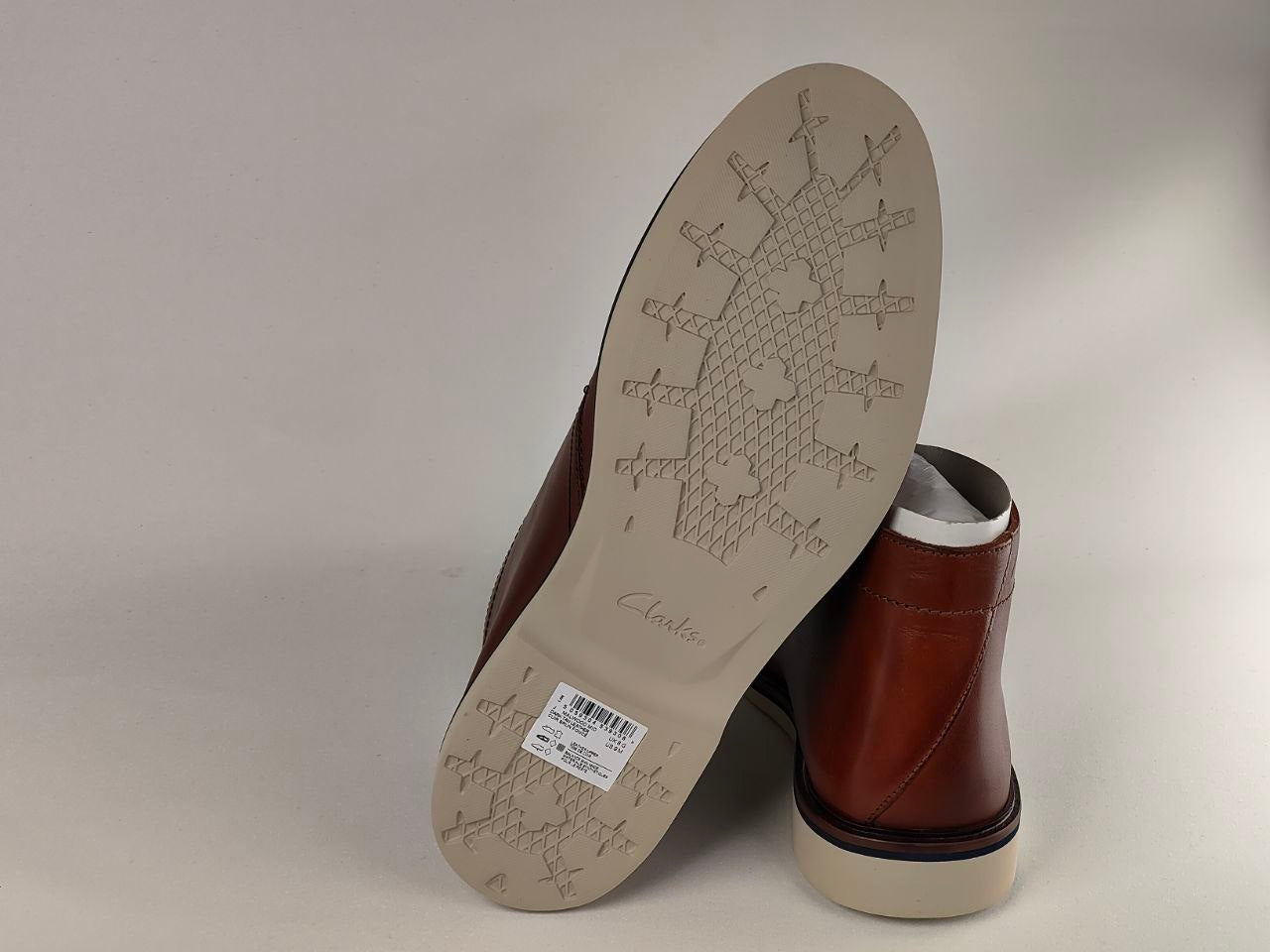 Brown leather boot with a visible sole on a light gray background