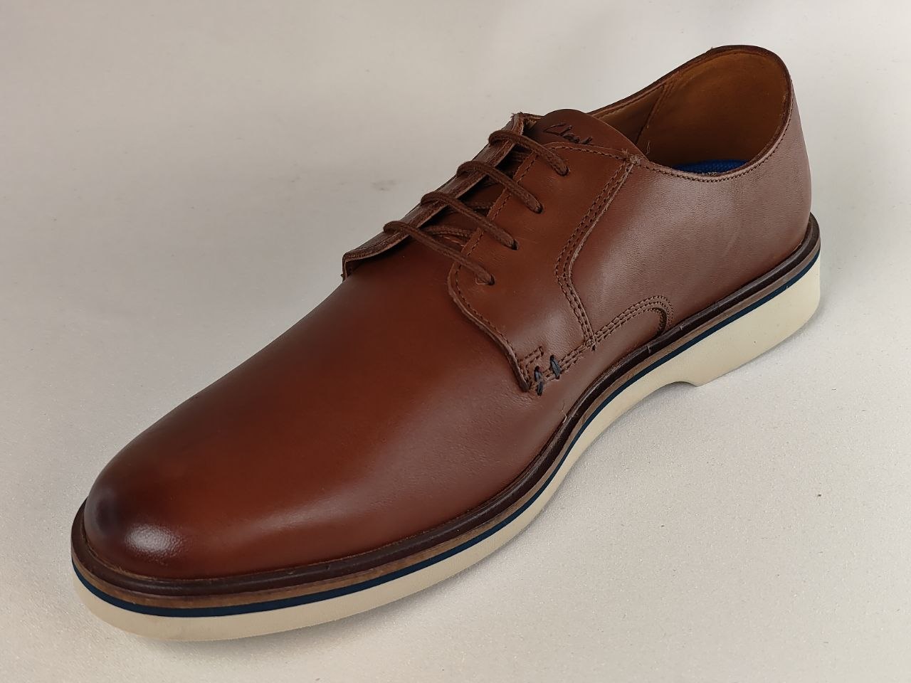 Brown leather shoe on a beige background