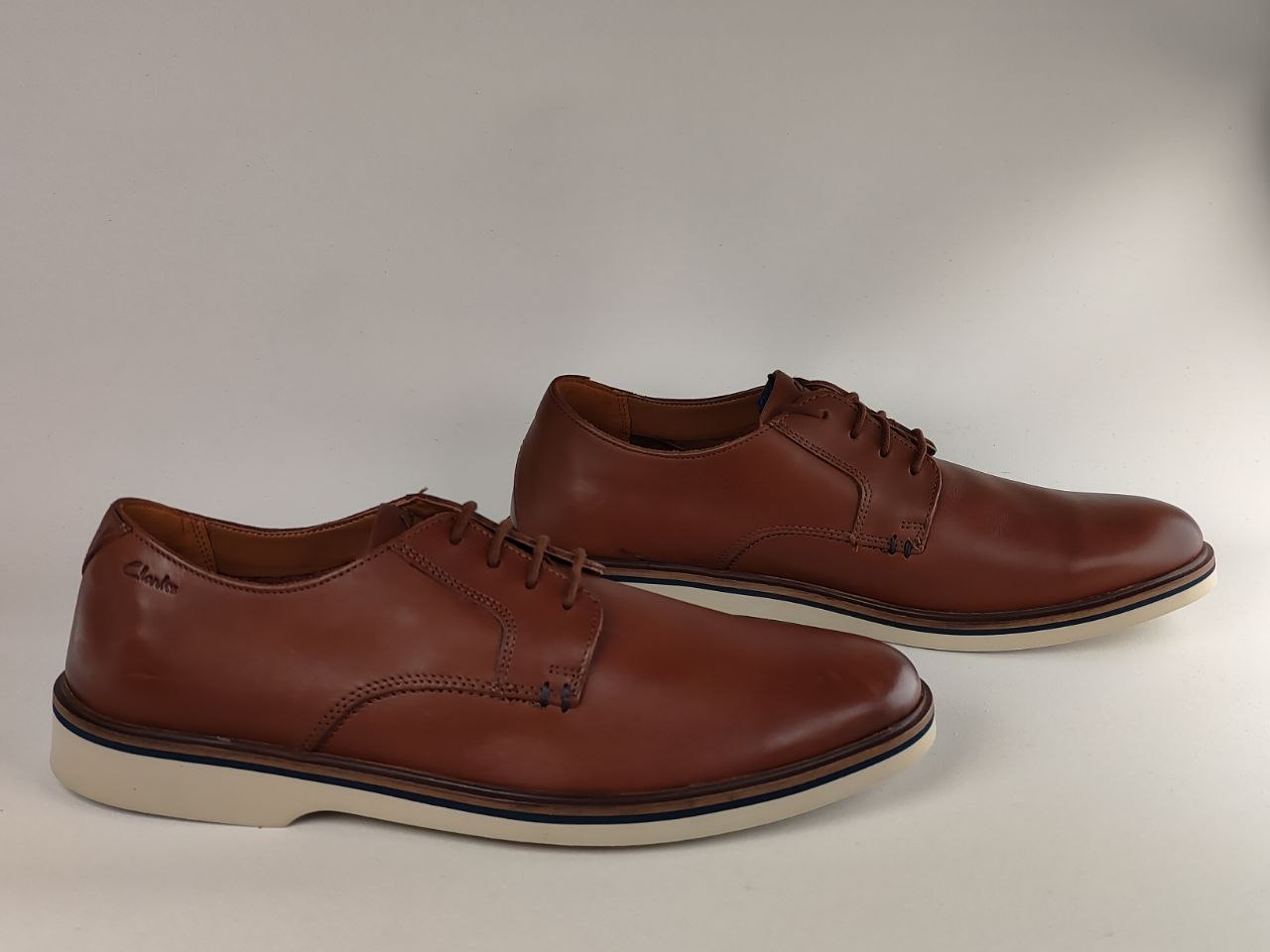 Pair of brown leather dress shoes on a light gray background