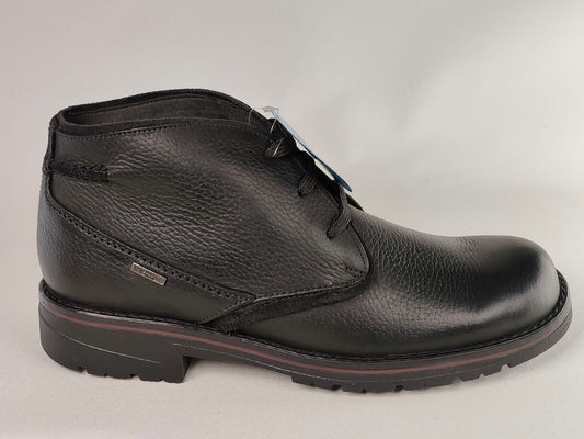 Black leather boot on a light gray background