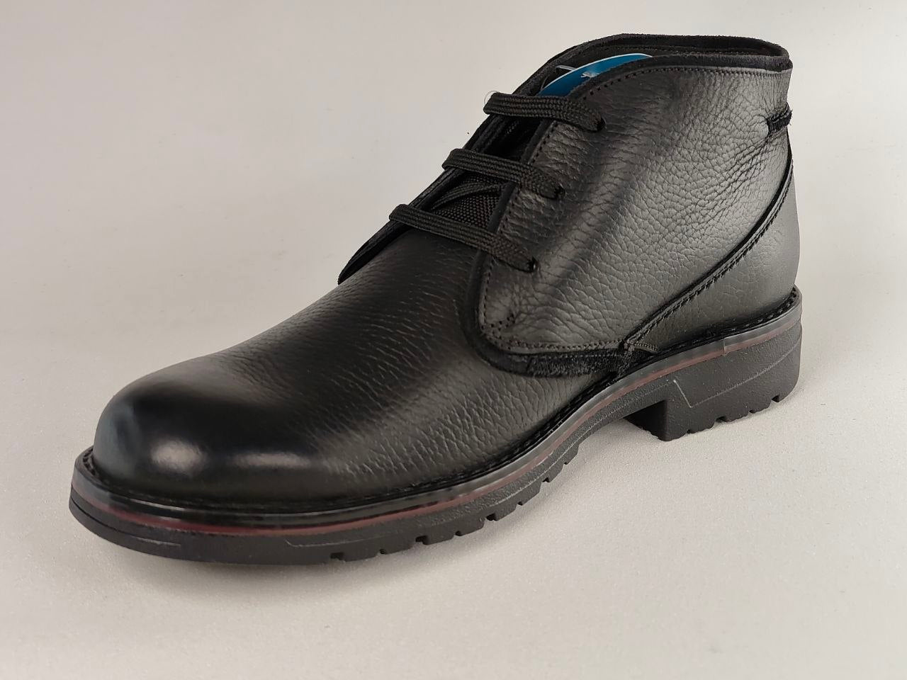 Black leather shoe on a light gray background