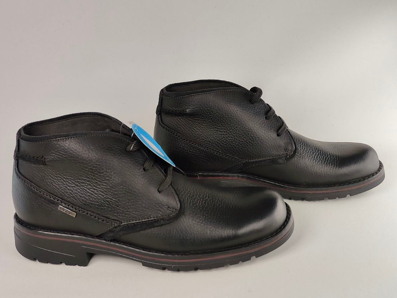 Pair of black leather boots on a light gray background