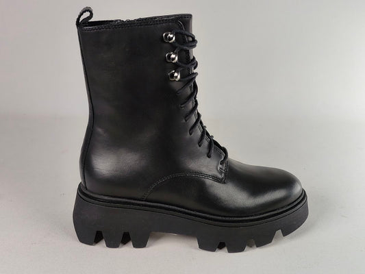 A single black leather lace-up ankle boot with a chunky lug sole and silver metal eyelets, photographed against a neutral light gray background.