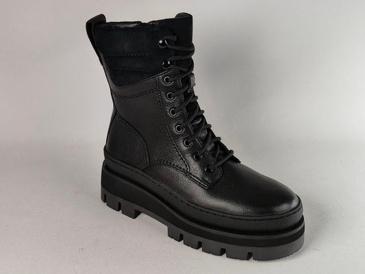 A single black lace-up combat boot with a chunky lug sole, shown from a three-quarters angle against a neutral gray studio background.