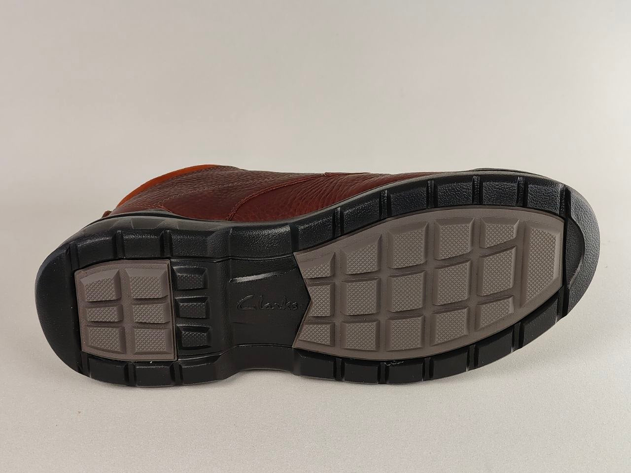 Brown shoe sole with black tread pattern on a light gray background
