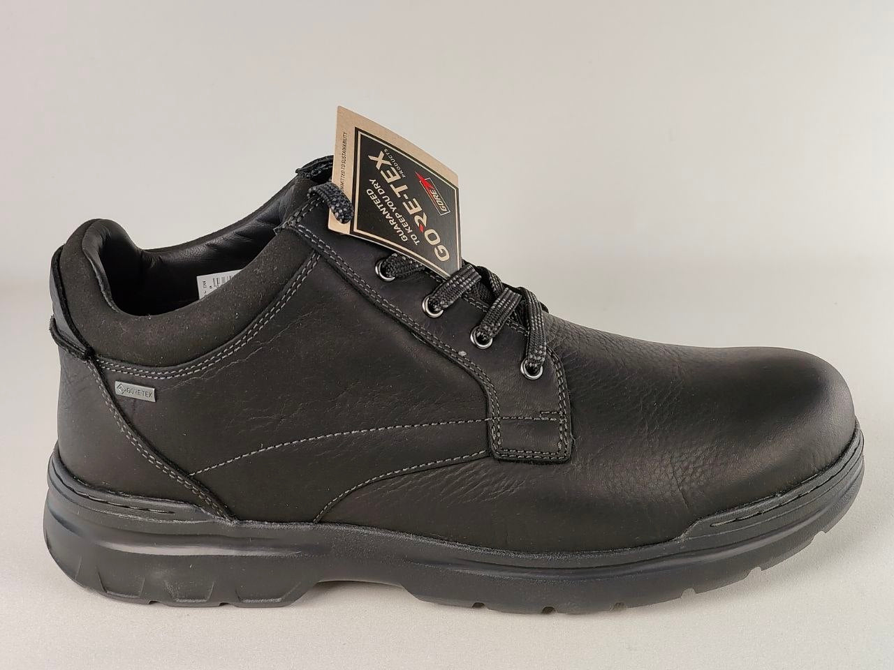Black leather shoe with a tag on a light gray background