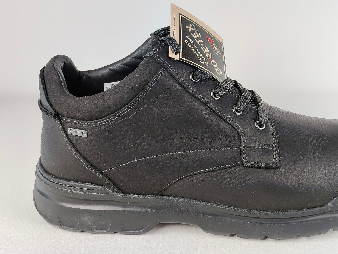 Black leather shoe with a brand tag on a white background