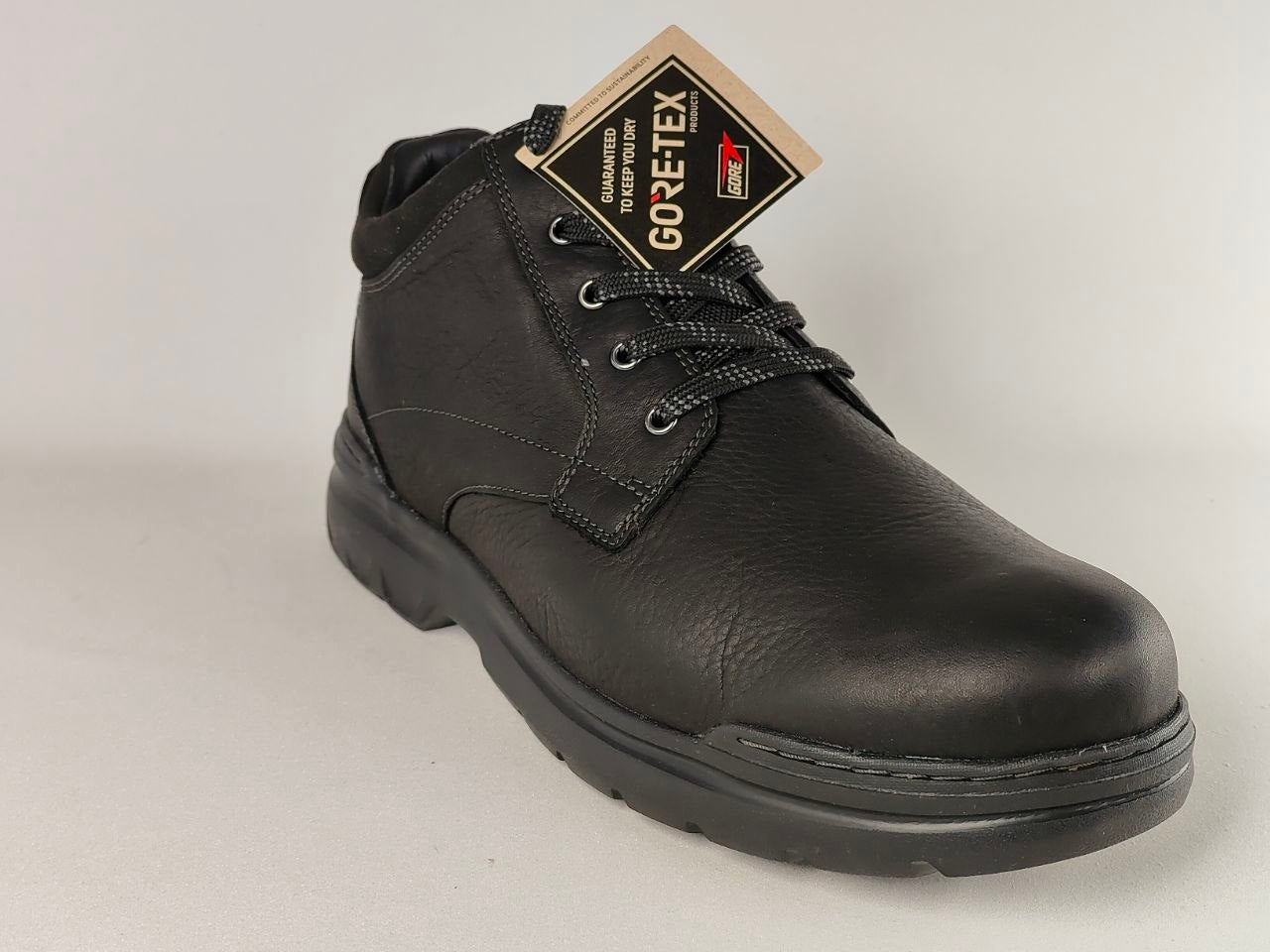 Black leather boot with GORE-TEX label on a light gray background
