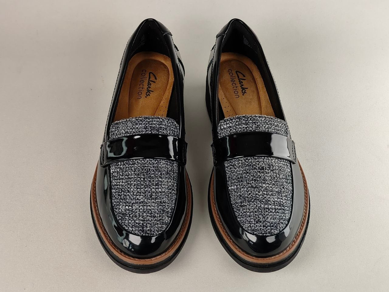 Pair of black loafers with gray textured pattern on a light gray background