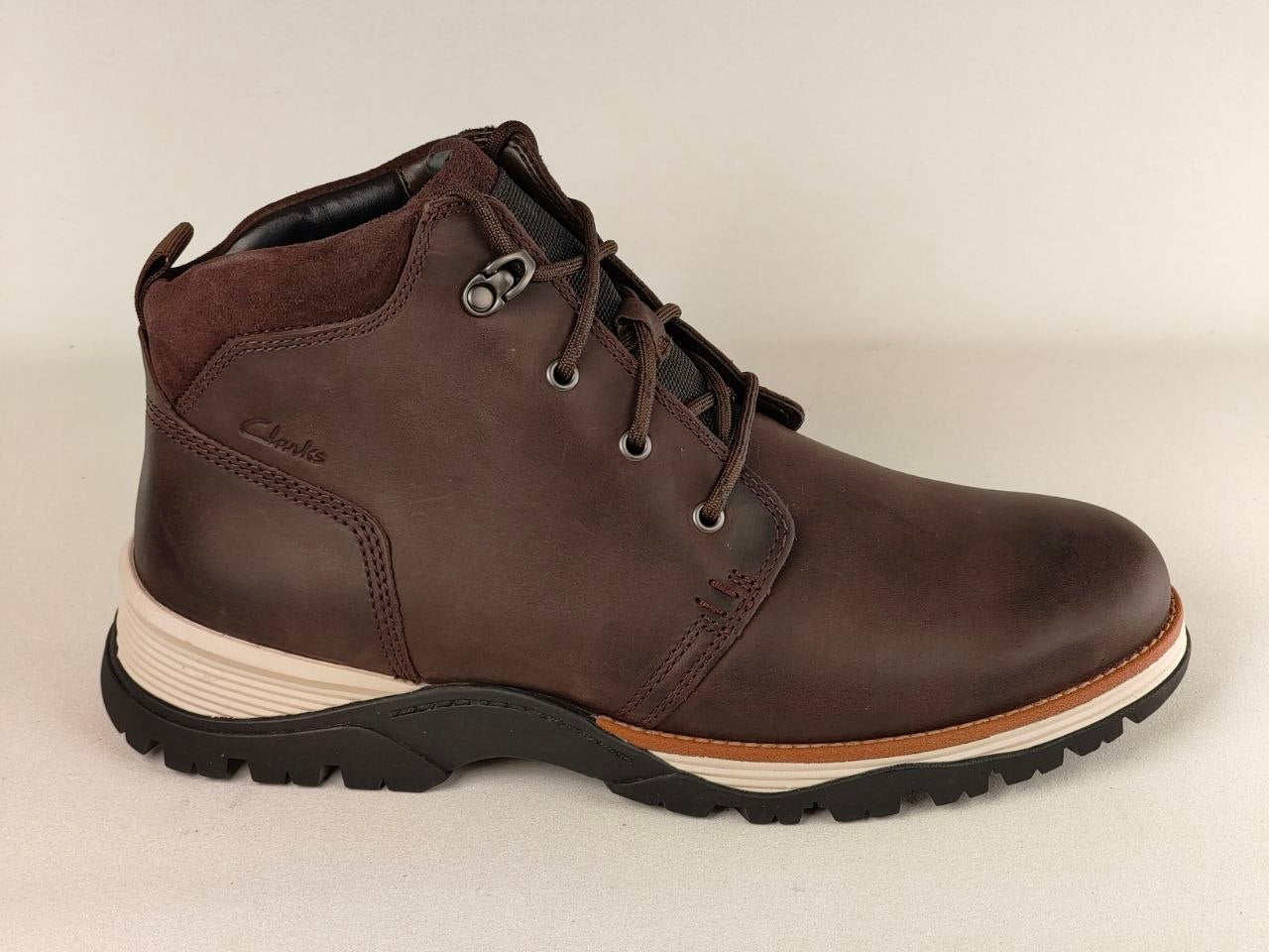 Brown leather boot with a white sole on a beige background