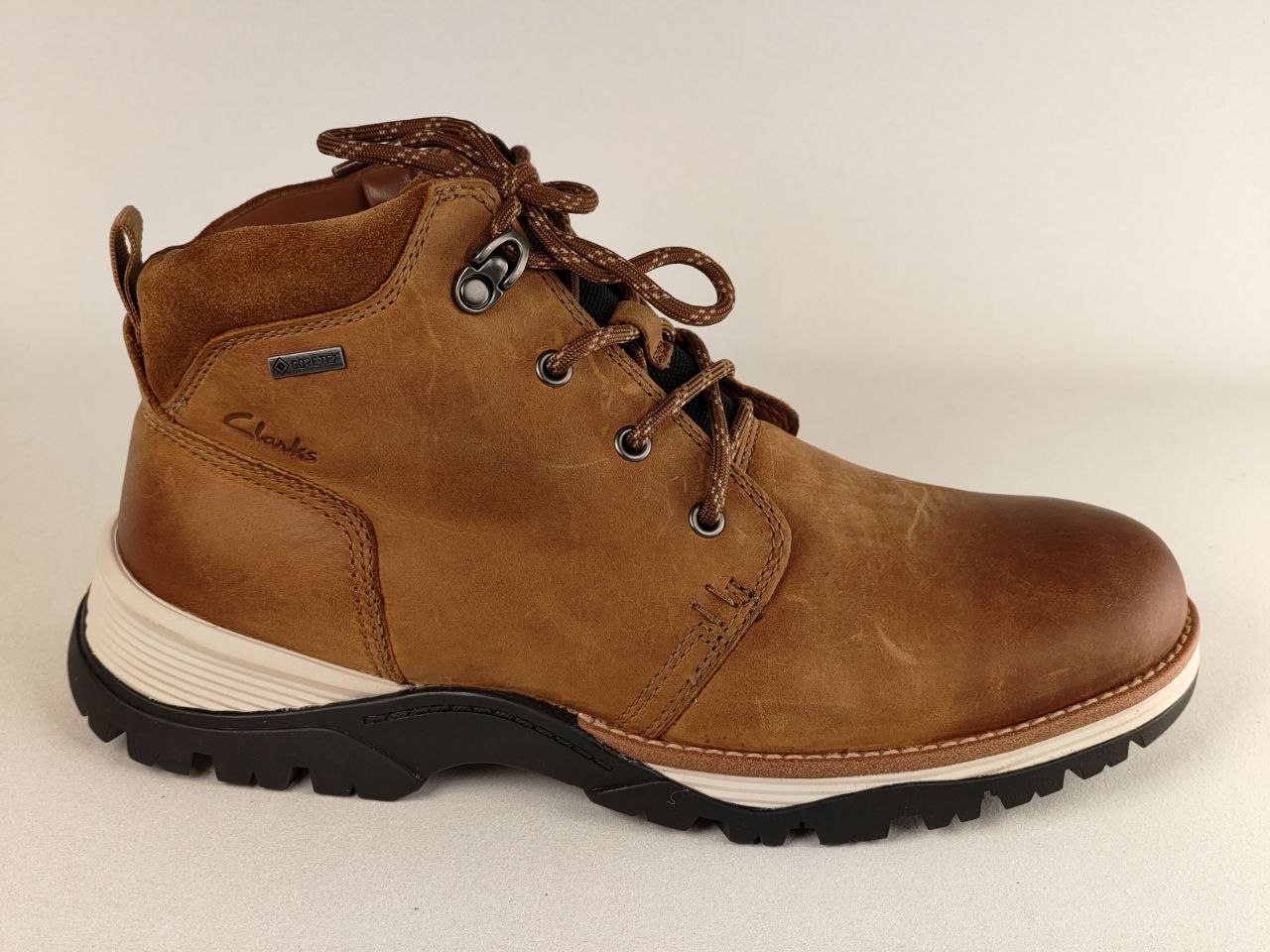 Brown leather boot with laces on a beige background