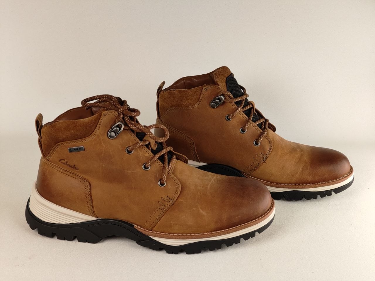 Pair of brown leather boots on a light gray background