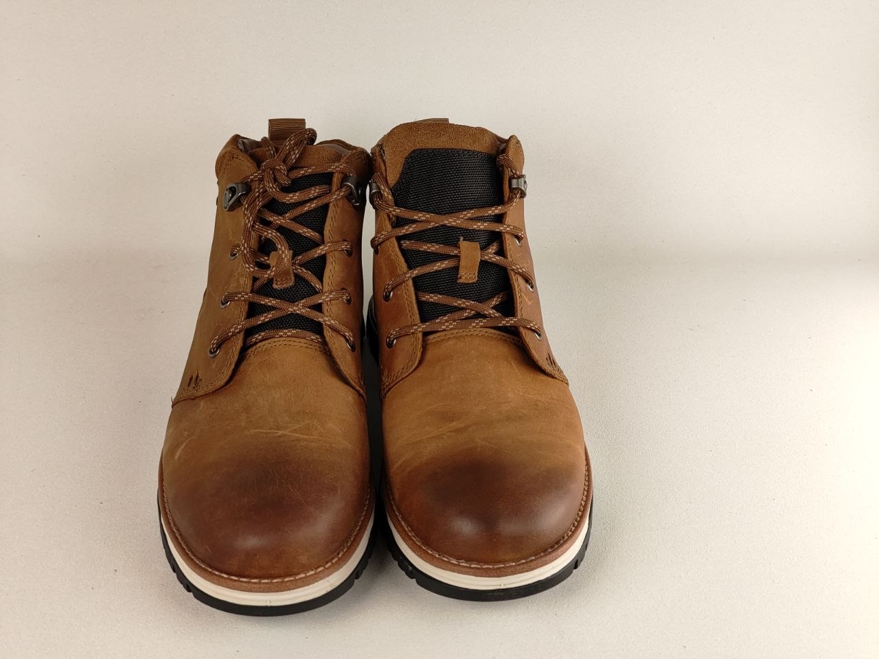 Pair of brown leather boots on a beige background