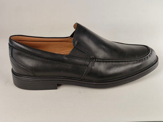 Black leather loafer shoe on a light gray background