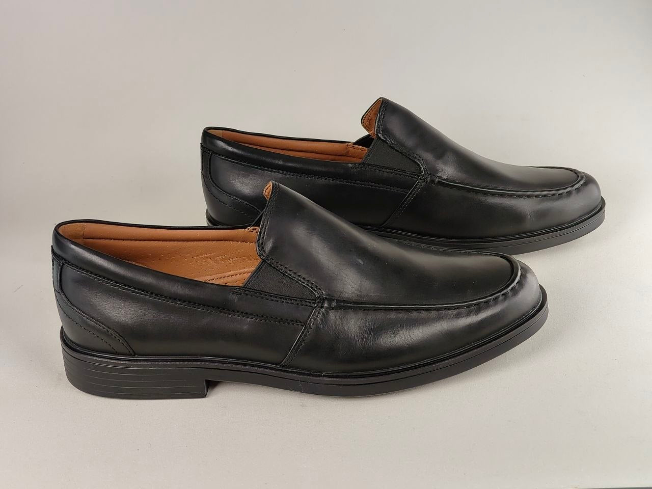 Pair of black leather loafers on a light gray background