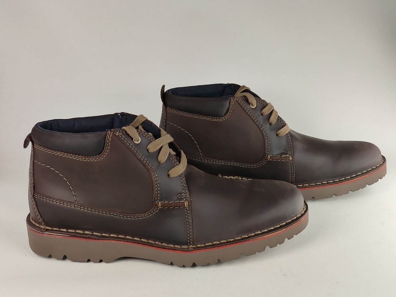 Pair of brown leather boots on a light gray background