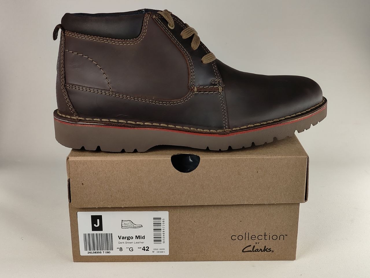 Brown leather boot on a Clarks branded box with a plain background