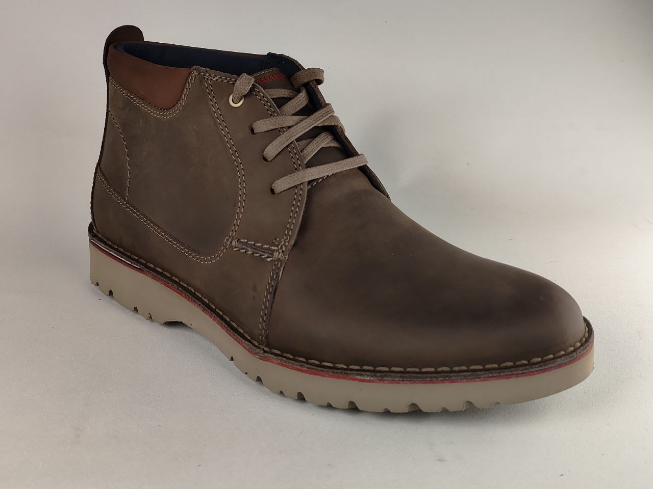 Brown leather boot on a light gray background
