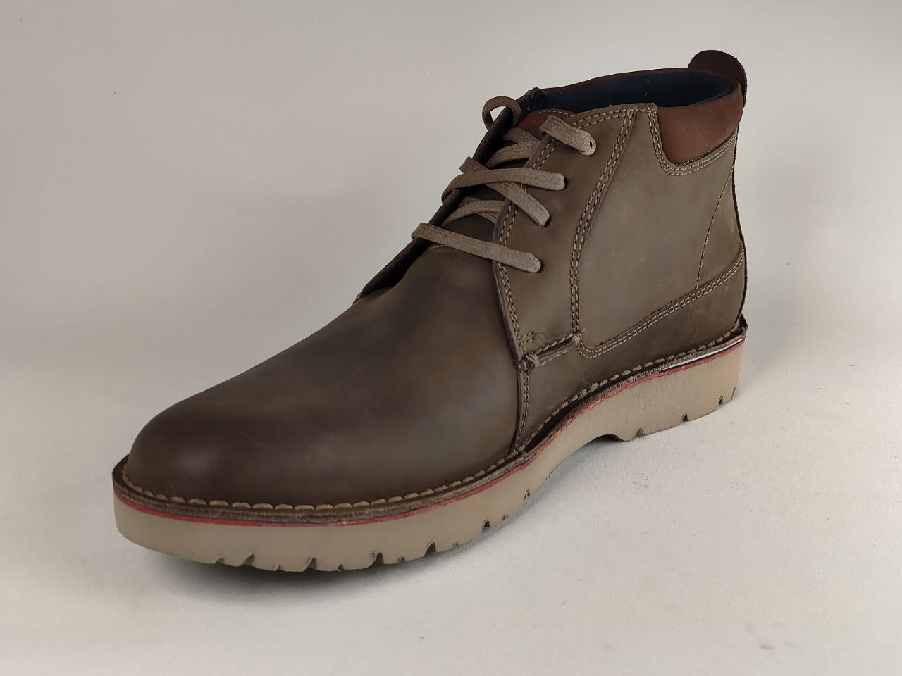 Brown leather boot on a light gray background