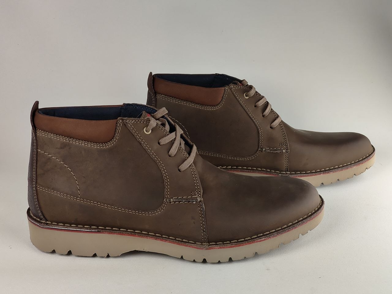 Pair of brown leather boots on a light gray background