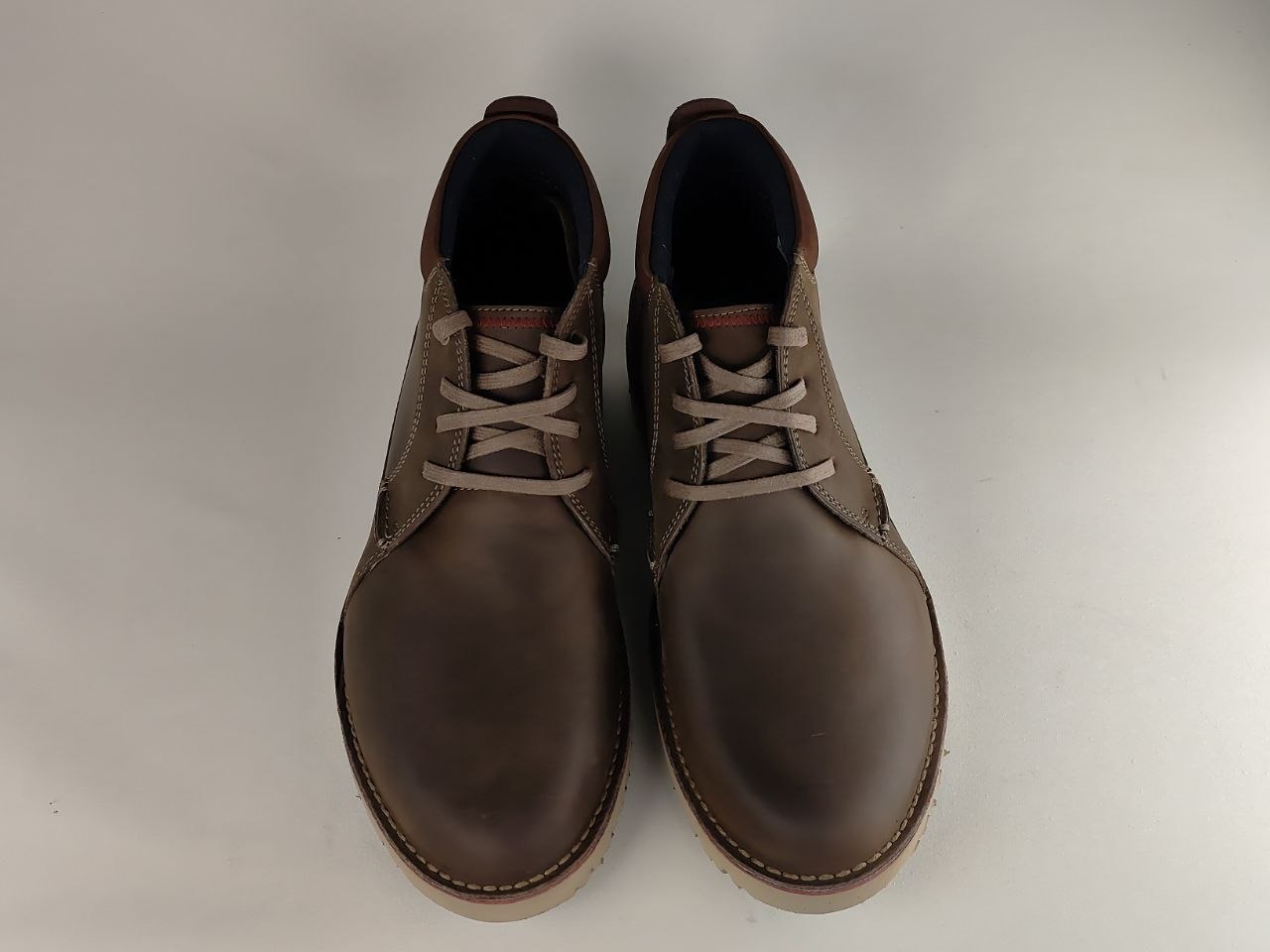 Pair of brown leather boots on a light gray background