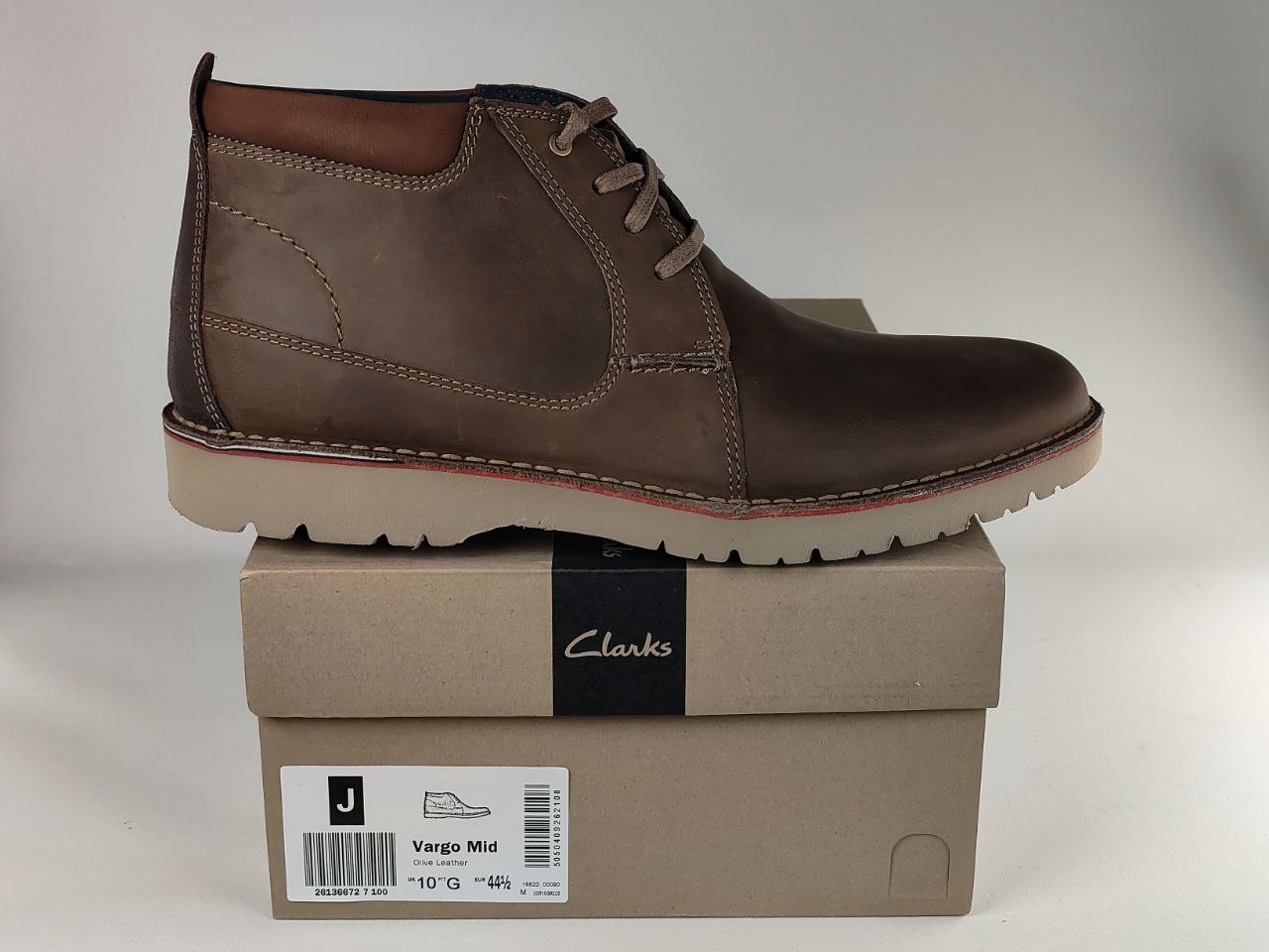 Brown leather boot on a Clarks shoe box with a plain background