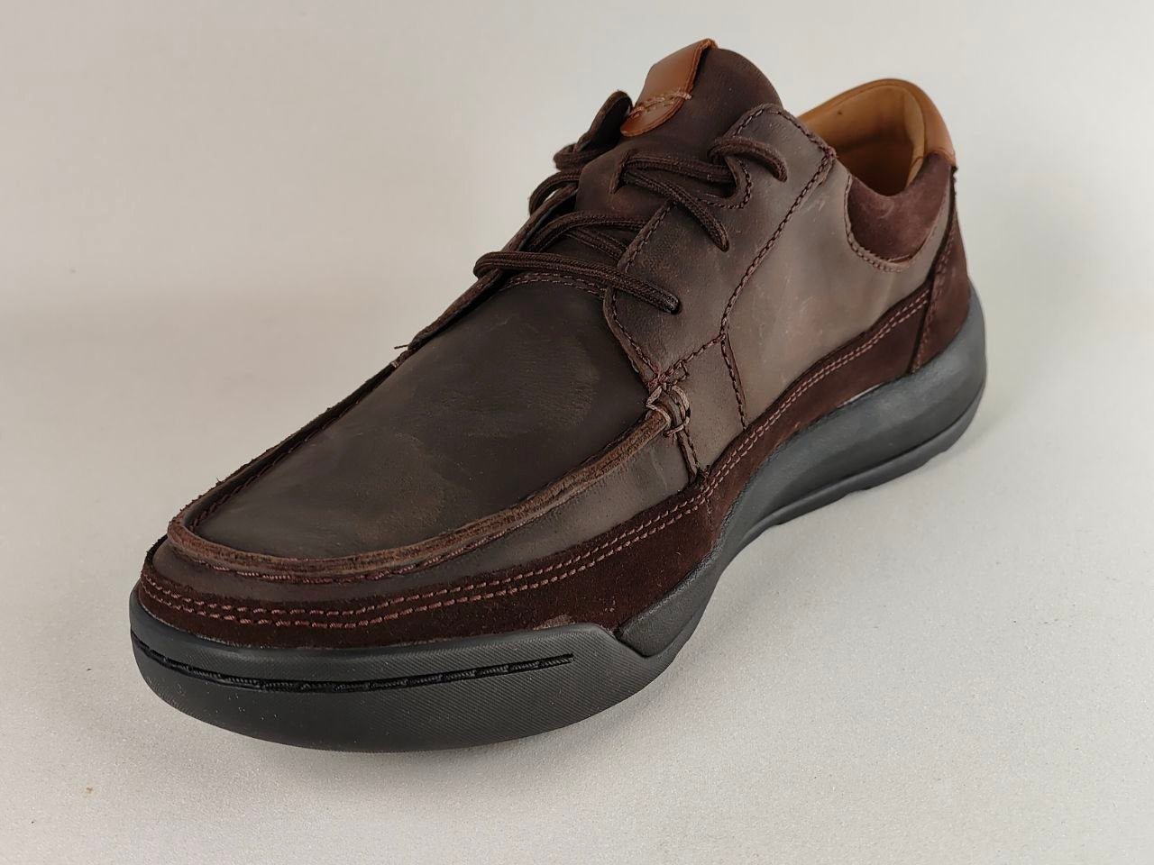 Brown leather shoe on a light gray background