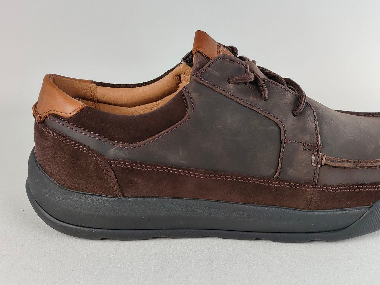 Brown leather shoes with a gray sole on a light gray background