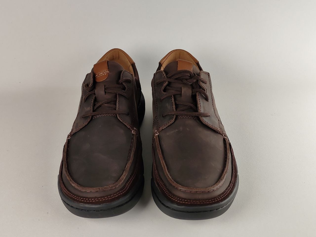 Pair of brown leather shoes on a light gray background