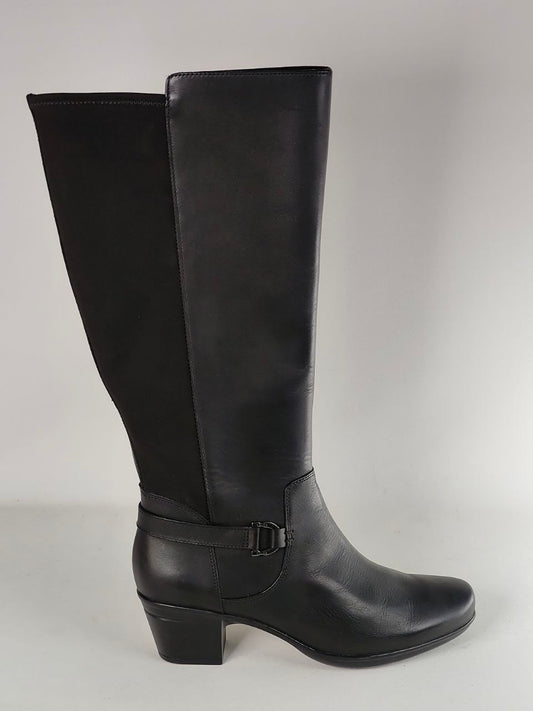 A single black knee-high boot with a block heel and ankle strap, photographed against a neutral light gray background.