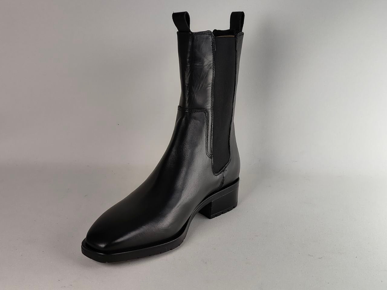 A single black leather Chelsea-style ankle boot with side gussets and pull tabs, photographed on a plain light gray studio background.