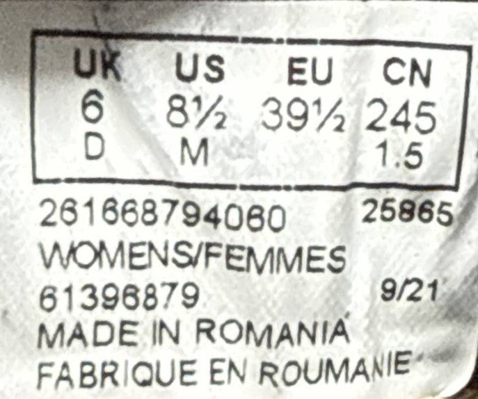 Close-up of a garment size label showing UK, US, EU, and CN size conversions for women's clothing, with printed numbers and text including 'WOMENS/FEMMES' and 'MADE IN ROMANIA'.