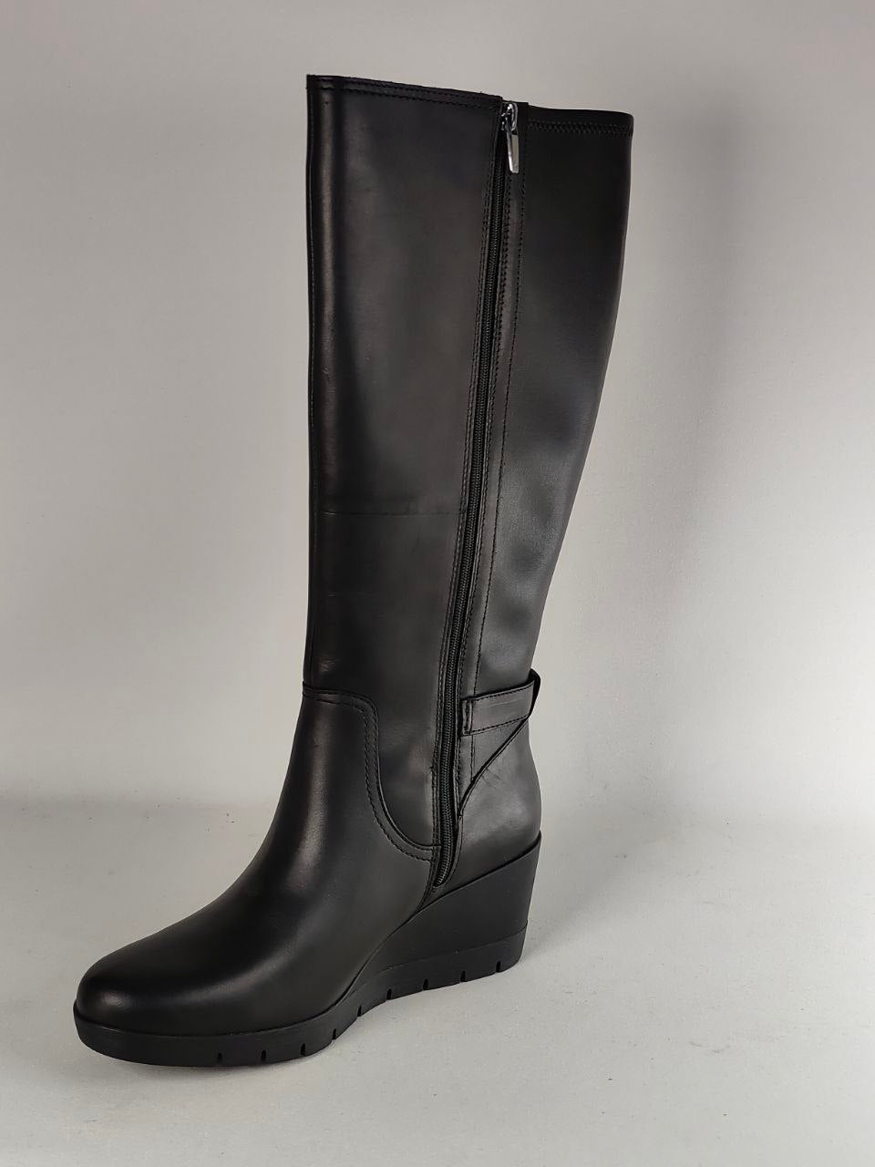 A single black leather knee-high boot with a side zipper, shown against a plain light gray studio background.