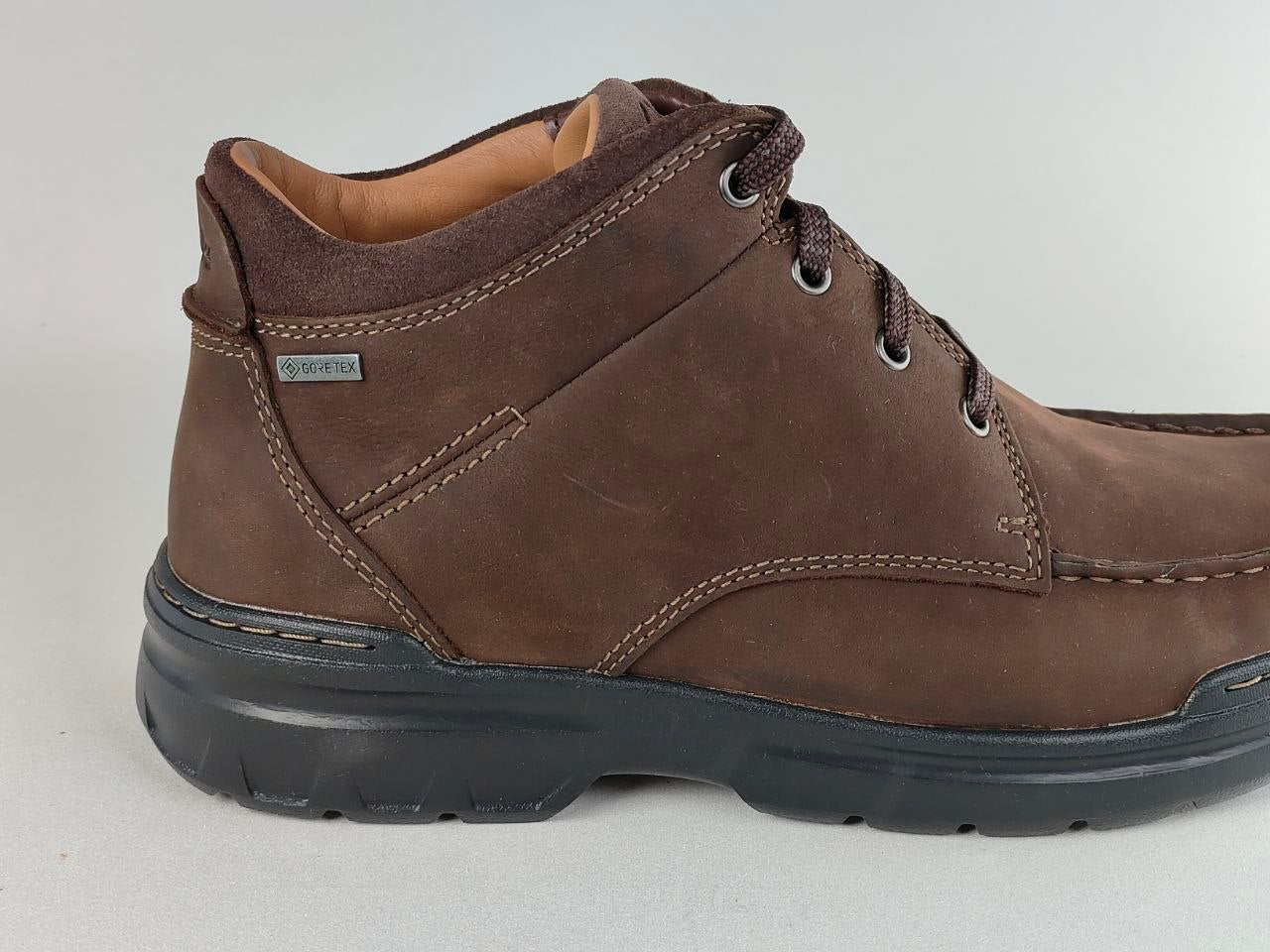 Brown leather boot with visible brand logo on a light gray background