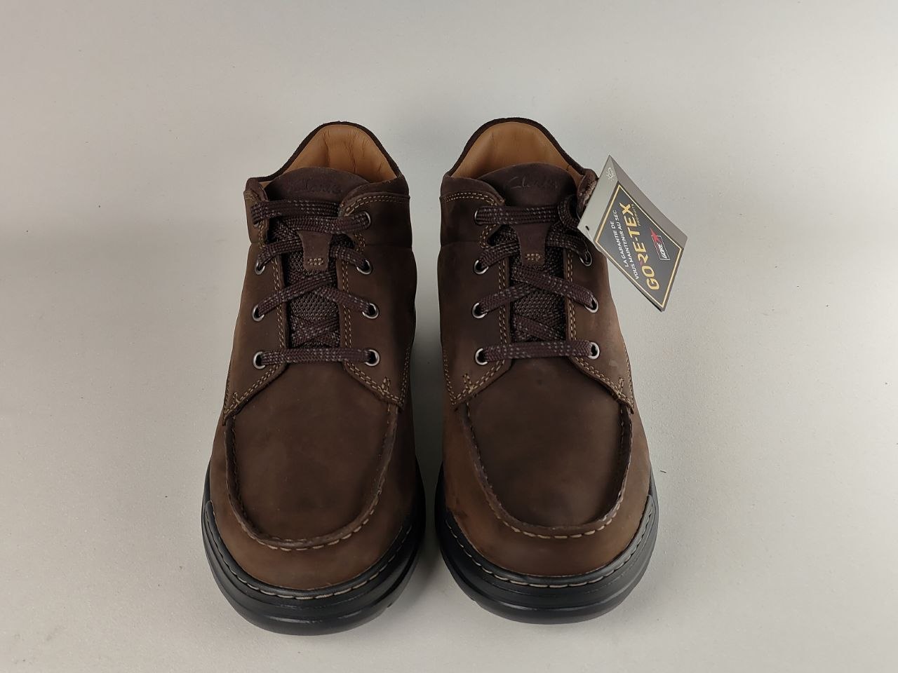 Pair of brown leather shoes with a GORE-TEX tag on a white background
