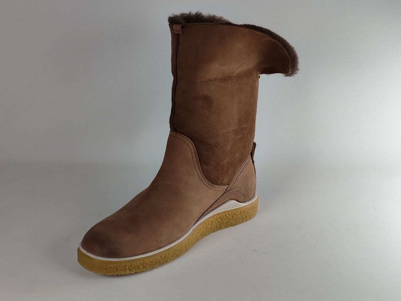 A brown suede mid-calf boot with a soft brown faux-fur trim at the top and a thick tan sole, shown against a plain light gray background.